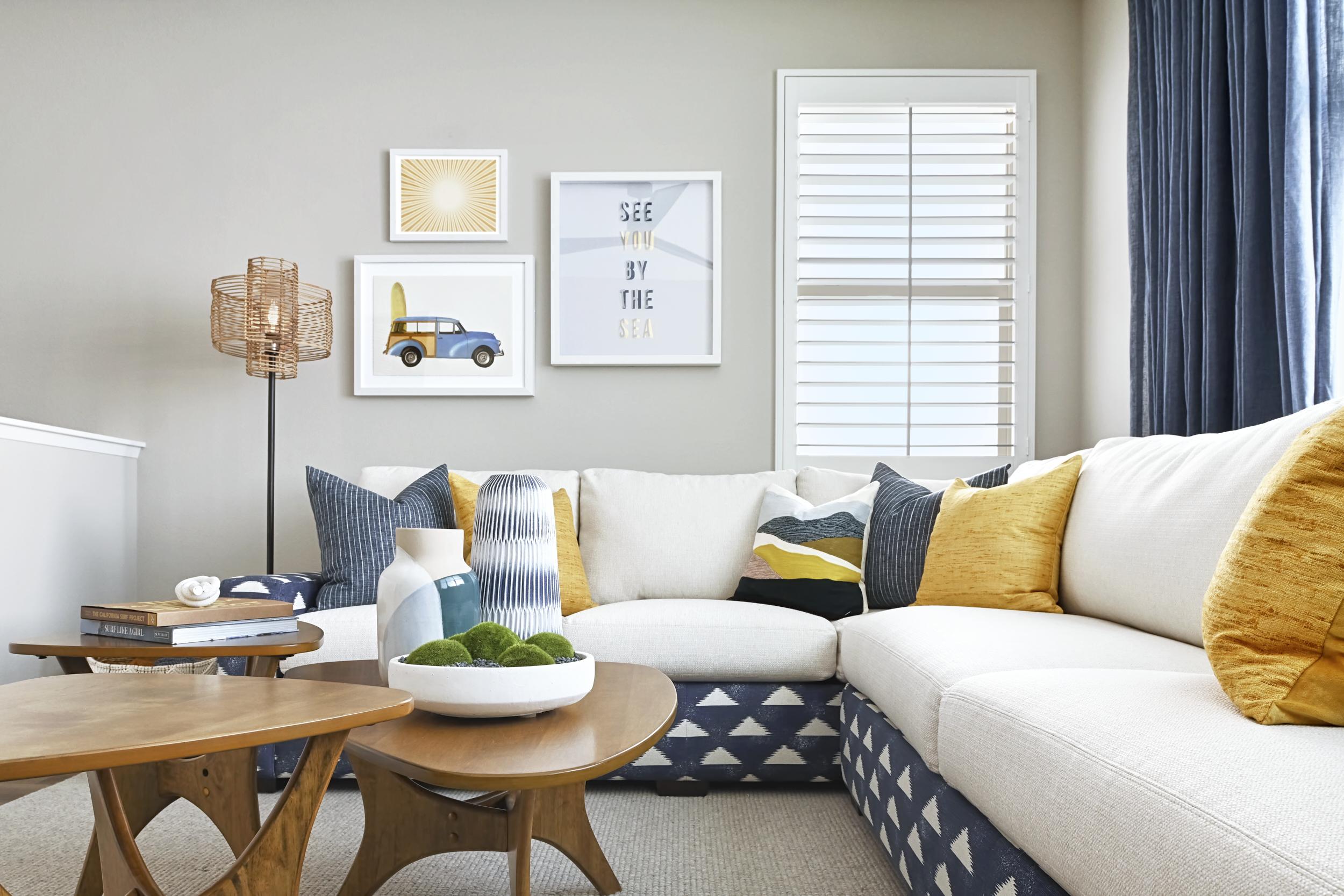lounge area with white couch with blue and yellow accent pillows