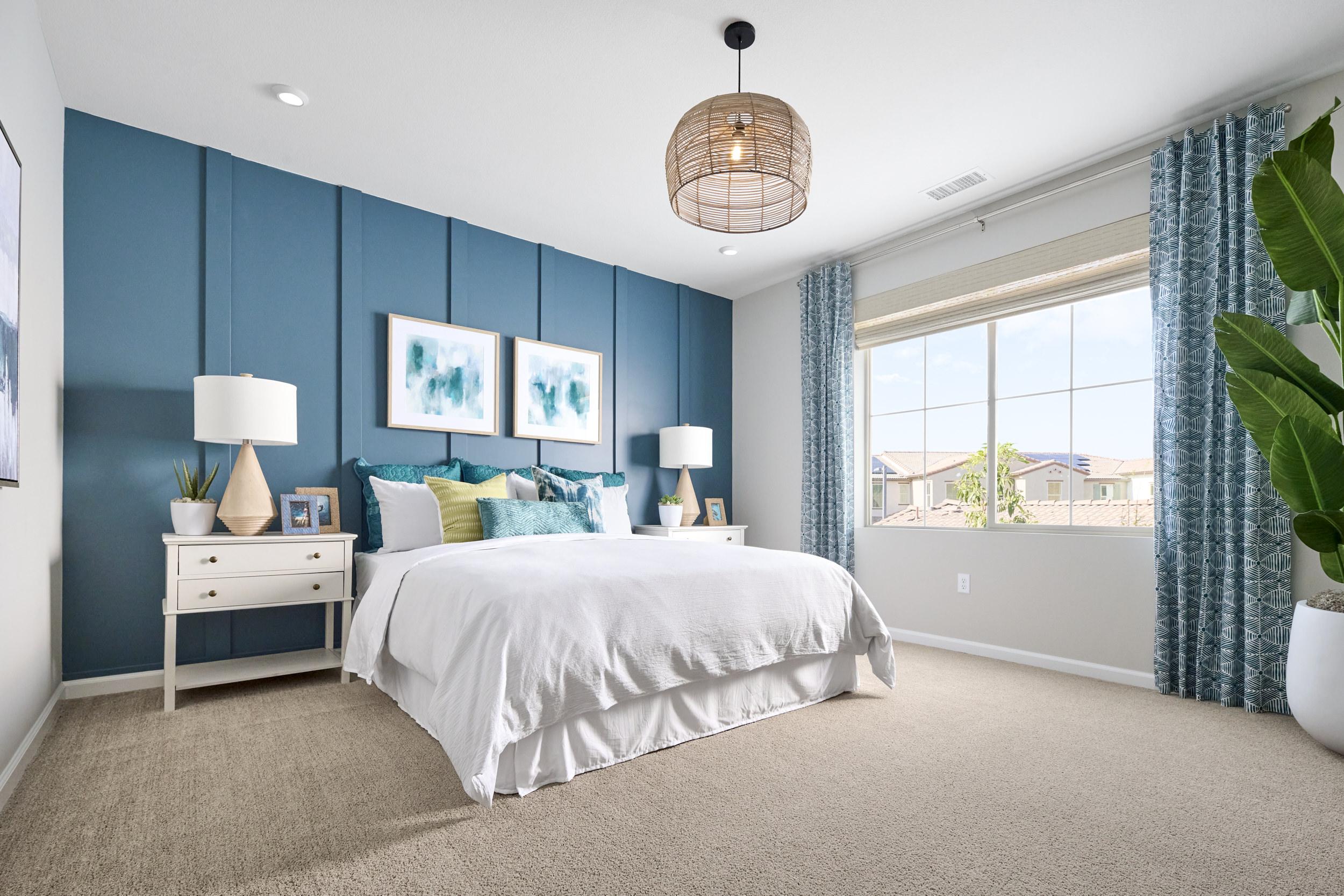 blue accent wall in white bedroom with beige carpet