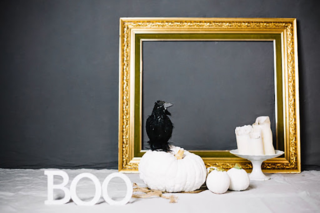 white pumpkins, a raven, a mirror, and boo